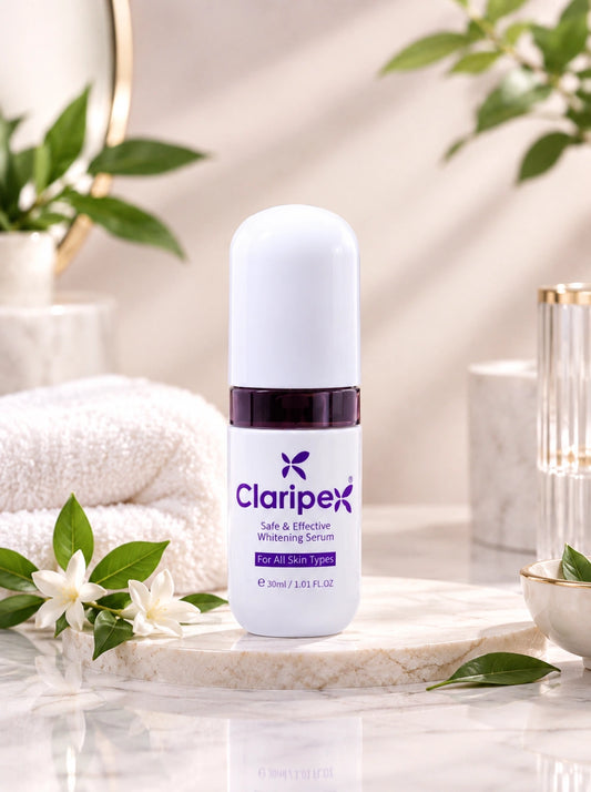 A bottle of Claripex Soft & Effusion Whitening Serum stands on a marble slab in a bright, spa-like setting with folded towels, green leaves, and decorative glassware in the background.